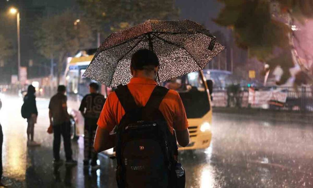 تصویر مردی با چتر در خیابان در فصل پاییز استانبول